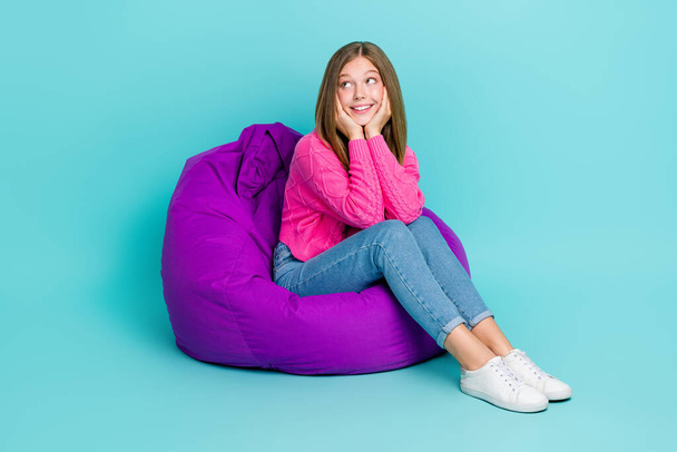 Full length photo of positive lovely lady sit comfort chair look empty space banner news information isolated on cyan color background. - Photo, image