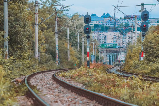 Chemins de fer sinueux avec feux de circulation pendant la saison d'automne avec des bâtiments au loin - Photo, image