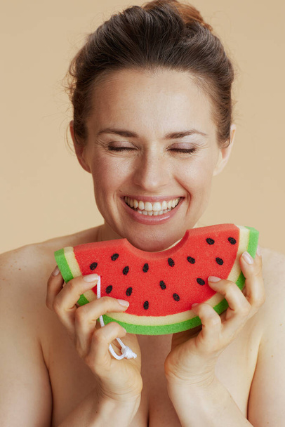 happy young woman with watermelon shower sponge against beige background. - Фото, зображення
