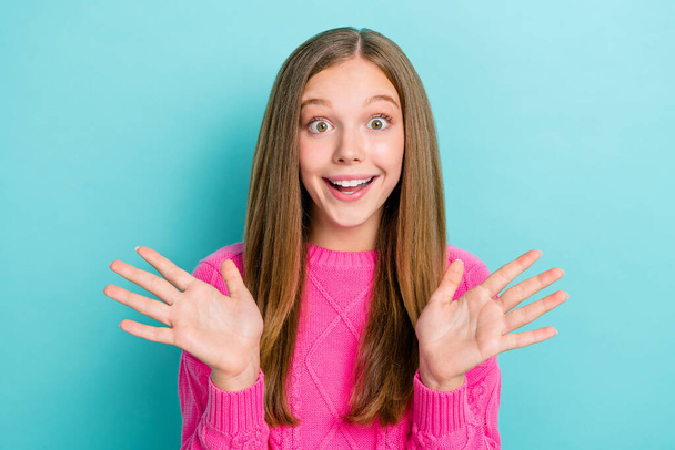 Closeup photo of teenager girl wear stylish pink knitted pullover hands up palms unexpected surprise speechless isolated on blue color background. - 写真・画像