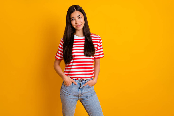 Photo of pretty charming young lady wear red clothes arms pockets empty space isolated yellow color background. - Fotografie, Obrázek
