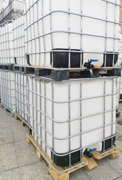 Viele Würfelwassertanks. 1000-Liter-Behälter im Freien gestapelt - Foto, Bild