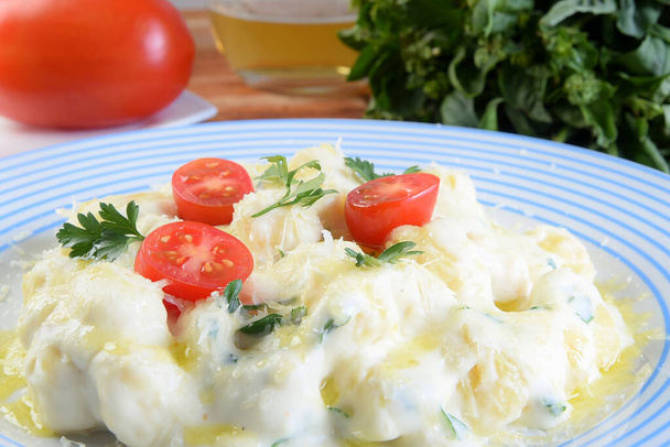delicious gnocchi pasta in white sauce with parmesan cheese, tomato, basil, herbs, healthy food from Italian and French cuisine - Foto, afbeelding