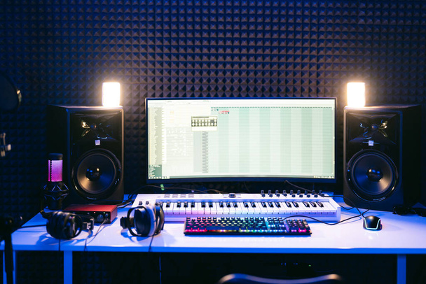 Estación de música del estudio. Consola de mezcla de audio profesional, pantalla, auriculares, luces, aislamiento de sonido - Foto, imagen
