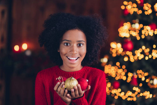 Portrait of funny cute cheerful small girl hands hold x-mas tree toy balls enjoy festive magic spirit house indoors. - Photo, Image