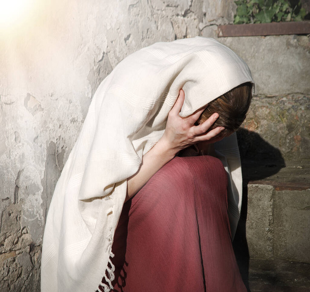 悲しみ失われた悲しみ泣き気分若い孤独な聖なるユダヤ人のメイド奴隷10代の女性メアリーは神イエス・キリストの信仰の希望を求める座っている感じ.古いレトロローマの歴史聖書の大人の人間の恥虐待白いイスラム教のホームテキストスペース - 写真・画像