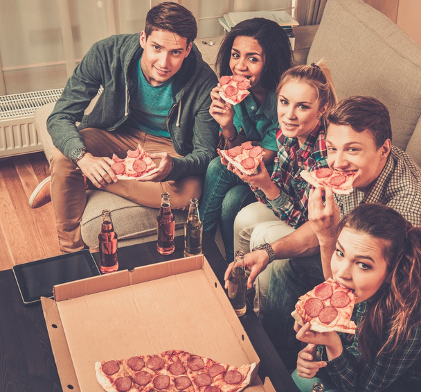 Monietniset ystävät pizzan ja juomapullojen kanssa
 - Valokuva, kuva