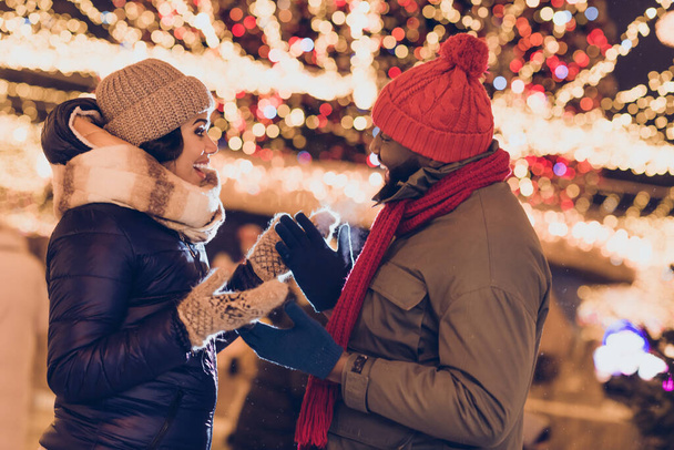 Fotografie legrační vzrušený manžel manželka nosit zimní sezónu oblečení mluvení chůze vánočního trhu mimo městské město ulice. - Fotografie, Obrázek
