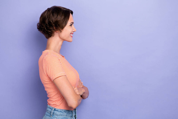 Side profile photo of young pretty cute gorgeous woman wear striped t-shirt toothy smile crossed arms look empty space promo isolated on violet color background. - Valokuva, kuva