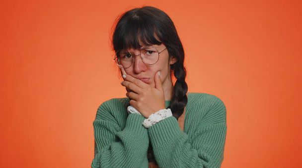 Hipster young woman touching sore cheek suffering from toothache cavities or gingivitis waiting for dentist appointment gums disease. Adult girl indoors studio shot isolated alone on orange background - Photo, Image