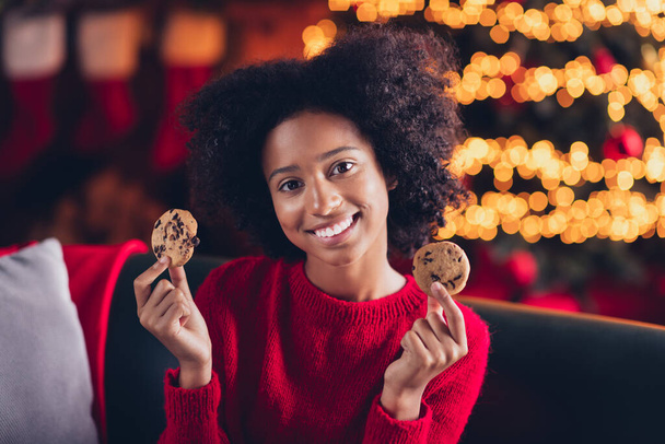 Photo of positive pretty lady toothy smile hand hold delicious tasty chocolate sweets enjoy winter season magic time indoors. - Фото, зображення