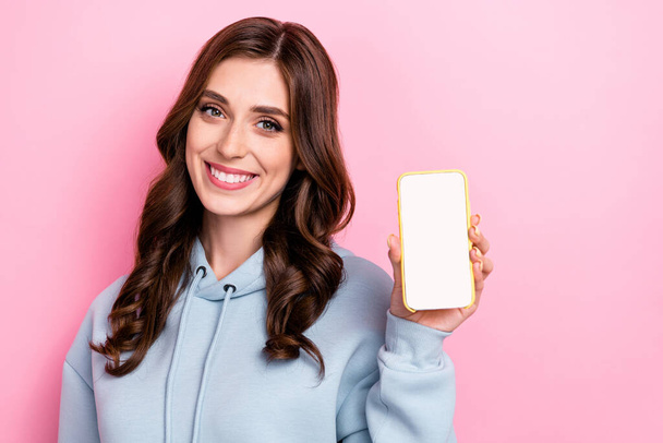 Photo of cheerful pretty lady toothy smile hand hold showing empty space telephone display isolated on pink color background. - Φωτογραφία, εικόνα