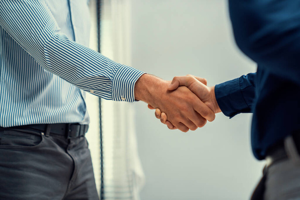 Two competent businessmen shake hands after successfully concluding a trading arrangement or business meeting. - Foto, Imagem