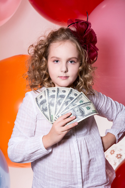 Teen girl holding a fan in her hand dollars. - Фото, изображение