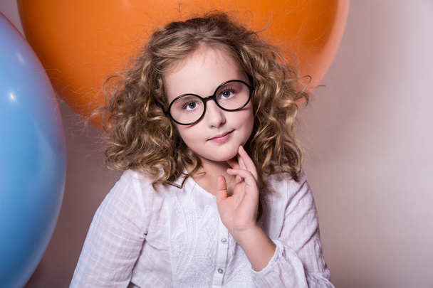 Beautiful, smart curly teen girl in glasses on the background of - Fotó, kép