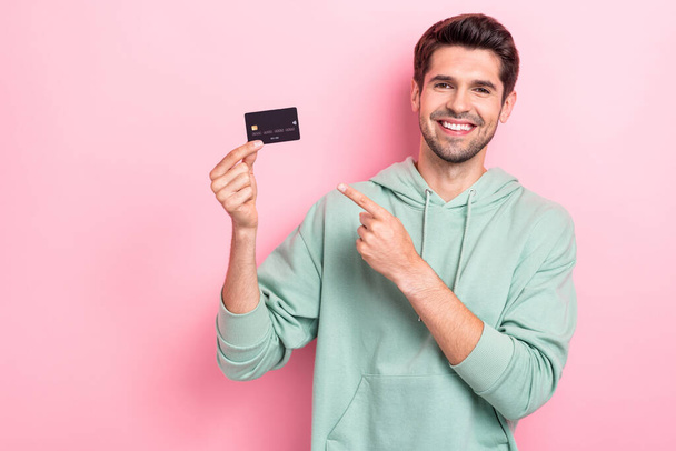 Portrait of cheerful person direct finger arm hold plastic debit card isolated on pink color background. - Photo, Image