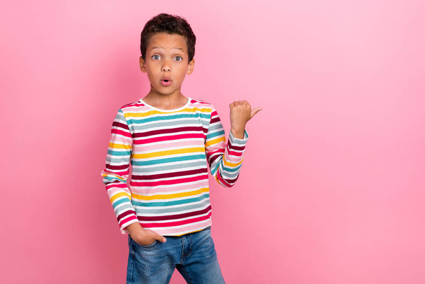 Foto portrét roztomilé latinsky malý chlapec bod nakupování copyspace dojem oblečený trendy pruhované vzhled izolované na růžové barevné pozadí. - Fotografie, Obrázek