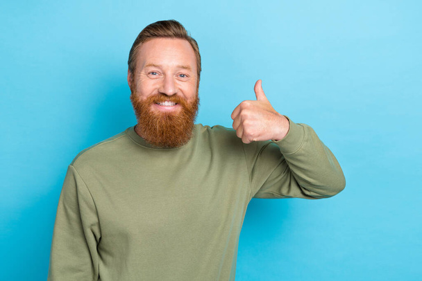 Photo portrait of nice young man showing thumb up cheerful good mood dressed stylish khaki clothes isolated on aquamarine color background. - Foto, immagini
