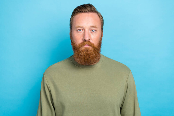 Photo of serious handsome bearded man with ginger hairstyle wear khaki long sleeve confident standing isolated on teal color background. - Foto, Bild