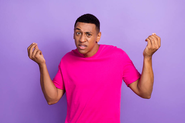 Photo of unhappy dissatisfied young student guy wear pink t-shirt finger argue dont like his new history teacher eyebrow up isolated on violet color background. - Photo, image