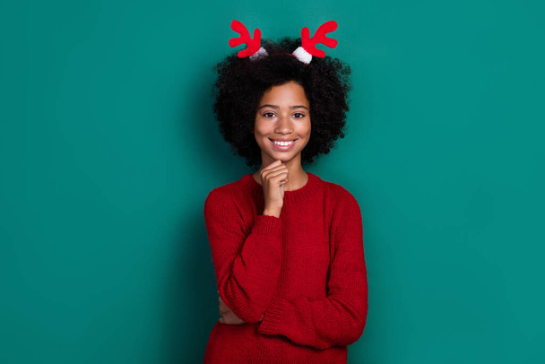 Photo of sweet girl toothy smile hand touch chin wear reindeer x-mas horns isolated on green color background. - Foto, Imagem