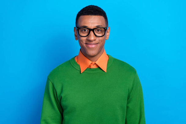 Photo of glad handsome clever man wear orange shirt under green sweatshirt glasses staring smiling isolated on blue color background. - Zdjęcie, obraz