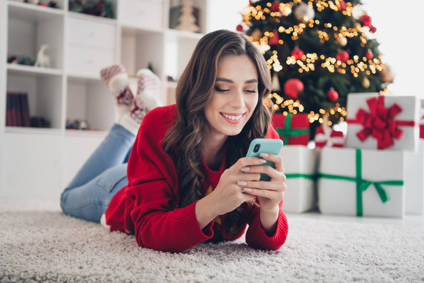 Photo of charming lady lying floor typing friends write greeting instagram facebook post share followers enjoy favorite season room indoors. - Photo, Image