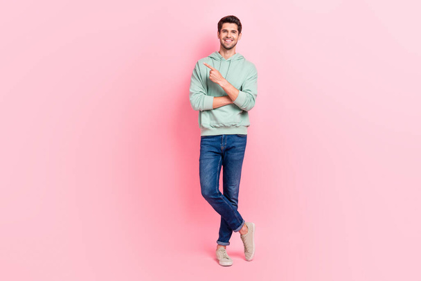 Full length photo of nice cool boy dressed khaki clothes denim arm direct empty space banner announcement isolated on pink color background. - Zdjęcie, obraz
