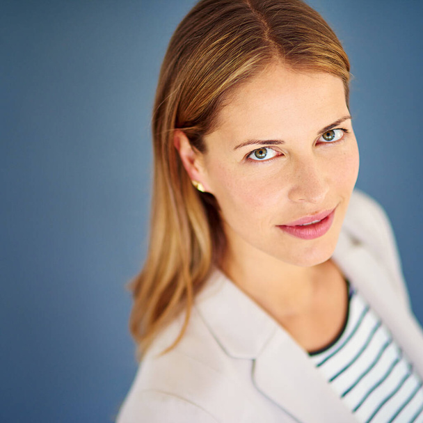 Shes always ahead of the pack. a woman dressed in office-wear posing against a blue background - Fotografie, Obrázek