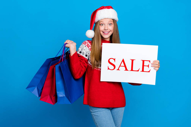 Photo of pretty joyful lady hand hold packs presents sharing news season total sale low prices showing ad isolated on blue color background. - 写真・画像