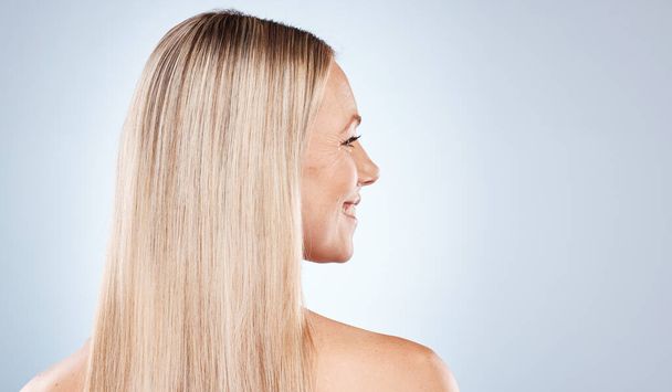 blonde happy woman, with healthy straight hair aesthetic on blue background in studio and flat iron hair care. Young girl with clean hair, side profile beauty with natural shine and luxury shampoo. - Photo, Image