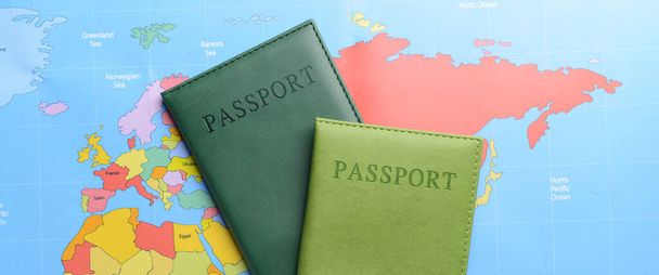 Δύο διαβατήρια στον παγκόσμιο χάρτη. Έννοια της μετανάστευσης - Φωτογραφία, εικόνα