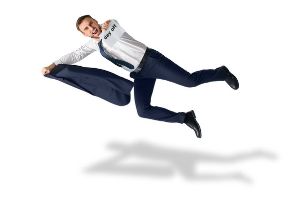 Flying happy businessman holding paper with text DAY OFF on white background - Фото, зображення