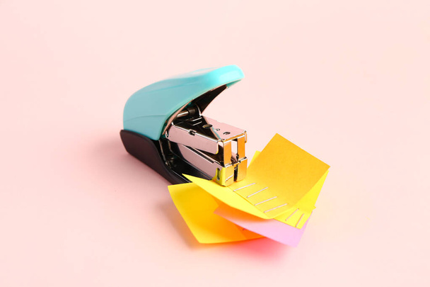 Office stapler with sticky notes on pink background - 写真・画像