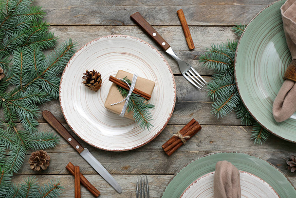 Noel dalları, köknar kozalakları ve ahşap arka planda tarçın olan güzel bir masa. - Fotoğraf, Görsel