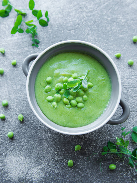 Fresh green pea soup bowl on gray concrete background - 写真・画像