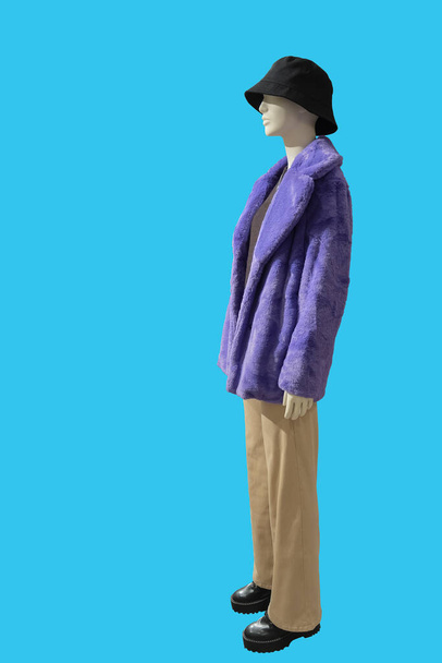 Pełna długość obraz samicy manekina wyświetlacza noszenie fioletowy faux futro płaszcz na niebiesko  - Zdjęcie, obraz