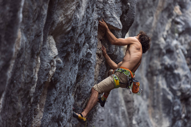 arrampicatore arrampicatore arrampica la roccia. un uomo forte supera un percorso difficile. relax e libertà nella natura. - Foto, immagini