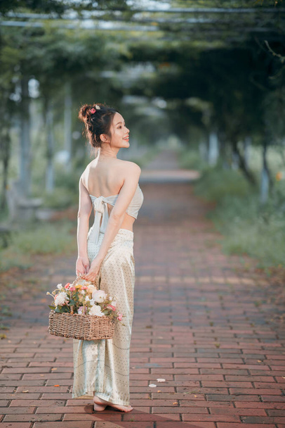 Das Mädchen in traditioneller chinesischer Kleidung steht im Garten - Foto, Bild