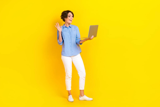 Full size photo of sweet girlish woman bob hairstyle wear white pants video call conference on laptop isolated on yellow color background. - Foto, afbeelding