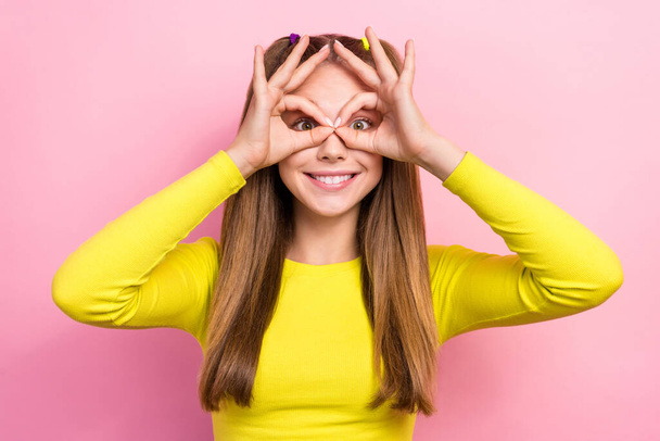Photo of charming funky school girl dressed yellow top showing arms spectacles having fun isolated pink color background. - Foto, imagen