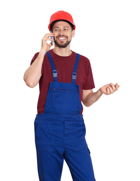 Professional repairman in uniform talking on phone against white background, space for text - Фото, изображение