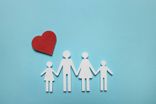 Paper family figures and red heart on light blue background, flat lay. Insurance concept - Photo, Image