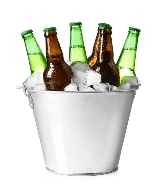 Metal bucket with different bottles of beer and ice cubes on white background - Fotoğraf, Görsel