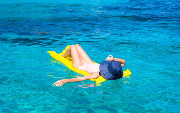 Nainen rentouttava puhallettava patja kirkkaassa meressä
 - Valokuva, kuva