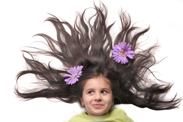 Petite fille aux cheveux et fleurs éventés
 - Photo, image