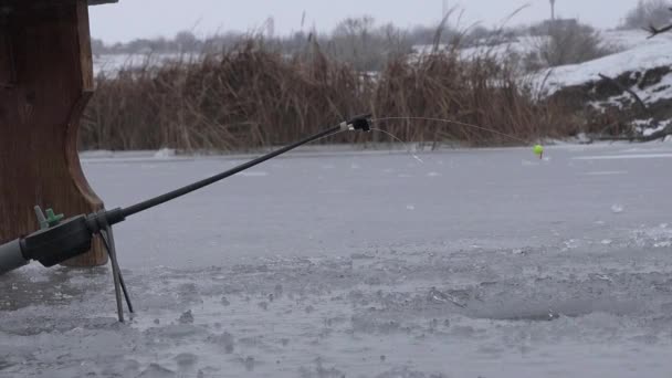 Kışın balık oltası nehirde buz delik yakınlarında - Video, Çekim