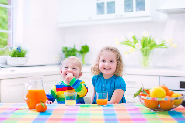Дети пьют апельсиновый сок
 - Фото, изображение