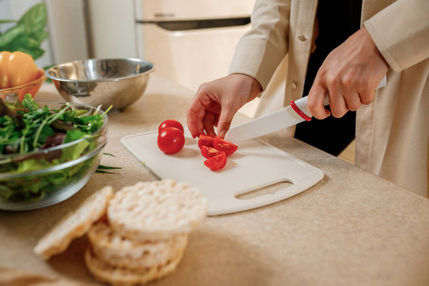 Közelkép egy nőről, aki vegetáriánus salátát készít a konyhában. Egészséges ételek és étrend koncepció életmód. Főzz otthon. - Fotó, kép
