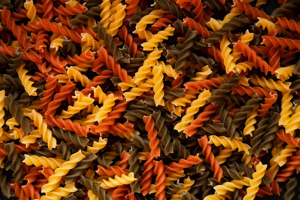 Tricolor fusilli paste spiral shape. Background of pasta. Top view. Close up. Selective focus. - Fotografie, Obrázek